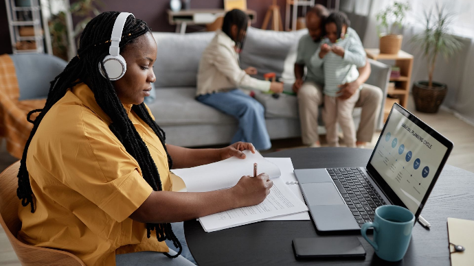 A mother is sitting in front of her laptop, studying at home