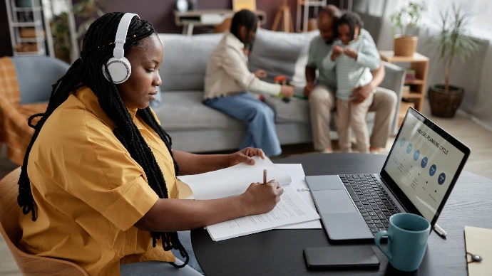 A mother is sitting in front of her laptop, studying at home