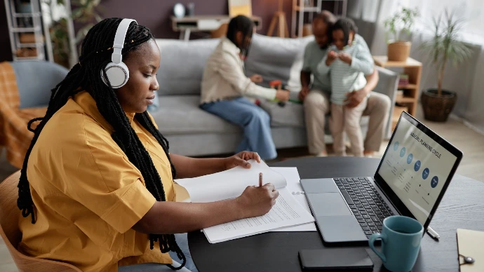 A mother is sitting in front of her laptop, studying at home